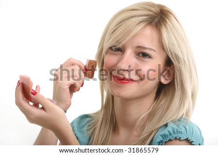 A young blonde doing make up with her small mirror.