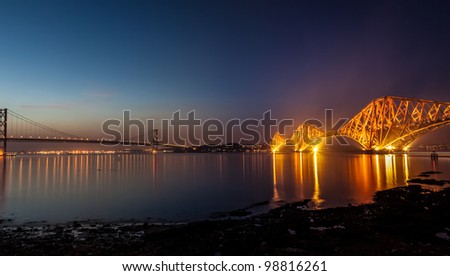 Forth Bridges, Scotland. The Rail Bridge, 1890 (floodlit), cantilever steel bridge, girder spans of 521m. The Road Bridge, 1964 with approaches is over 2km. Central span is over 1 km.