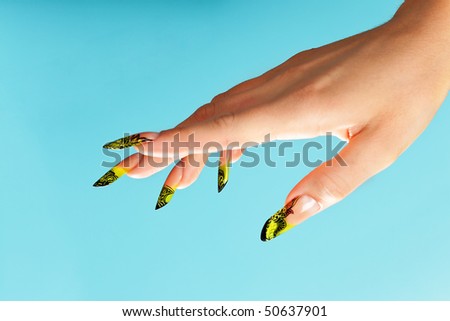 Human fingers with beautiful manicure in natural green style over blue