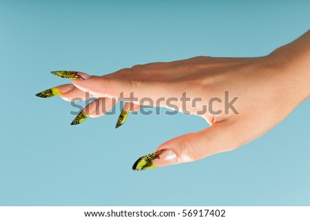 Human fingers with beautiful manicure in natural green style over blue