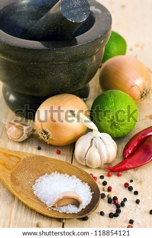 garlic, lime, onion, marinade ingredients, granite mortar on a wooden board