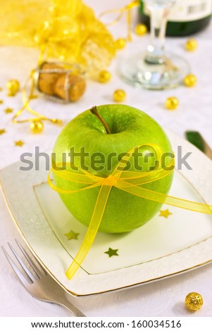 green apple with a beautiful ribbon on the holiday table as a concept of diet on holidays