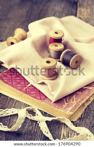 Old spools of thread, fabric on a wooden background