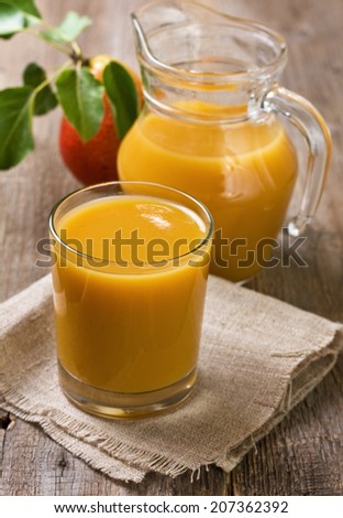jug and glass of pear juice, pear on the old wooden background