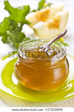 melon jam in a glass jar on a wooden background