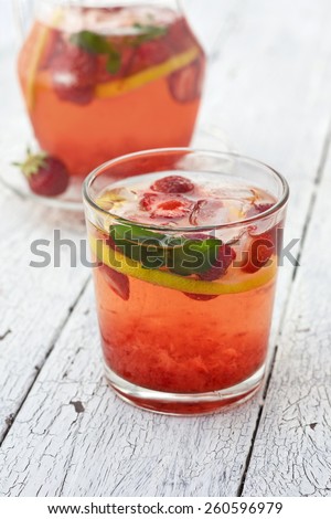 lemonade with strawberries on a wooden background
