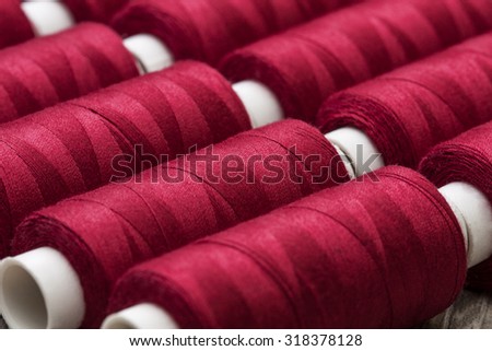 background of the ranks of red  spools of thread close-up