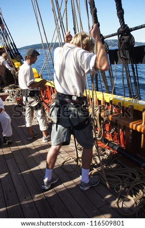 KIRKLAND, WASHINGTON - SEP 1 - The crew sets the sails of the Lady Washington     during a mock sea battle as part of Labor Day festivities on Sep 1, 2012 near Kirkland , Washington.