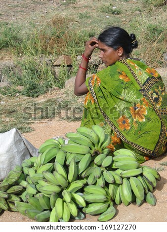 ORISSA INDIA - 11 NOV 2009 - Woman in green sari sells green bananas in Chatikona market, Orissa, India on 11 Nov 2009