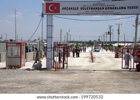 AKCAKALE, TURKEY - Jun 8, 2014 - People enter the Akcakale Syrian  refugee camp near the Syrian border,  in Southeastern Turkey, June 2014