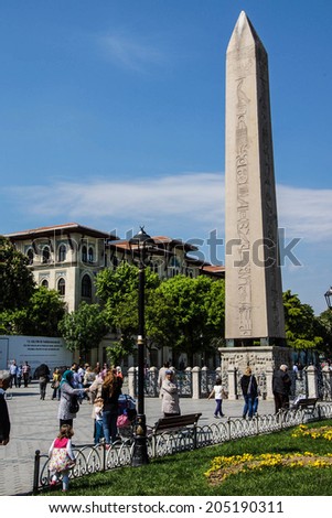 ISTANBUL, TURKEY - MAY 16, 2014 -Tourists walk by the Egyptian obelisk in the ancient site of the Hippodrome   in Istanbul, Turkey