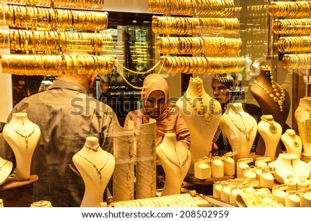BURSA, TURKEY - MAY 22, 2014 - Women with scarves choosing gold bracelets  in the bazaar of  Bursa, Turkey
