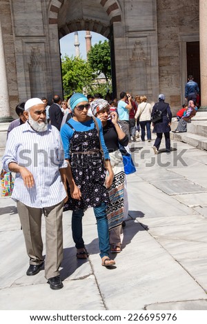 ISTANBUL - MAY 17, 2014 -  Veiled Turkish women move through the courtyard of the Blue Mosque after the call to prayer,  in Istanbul, Turkey