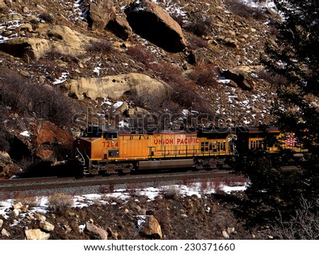 GLENWOOD CANYON, COLORADO - JAN 31, 2013 -Freight train runs through a narrow canyon in winter, Glenwood Canyon,  Colorado
