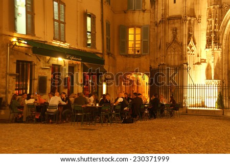 AVIGNON, FRANCE - SEP 30, 2011 -  Casual diners enjoy an evening meal near an old church on Sep 30, 2011  in Avignon, France