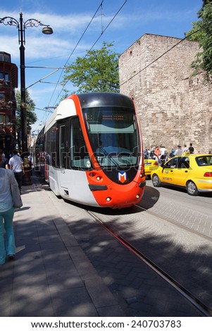 ISTANBUL - MAY 18, 2014 - Colorful tram rapid transit heads down to the Golden Horn  in Istanbul, Turkey