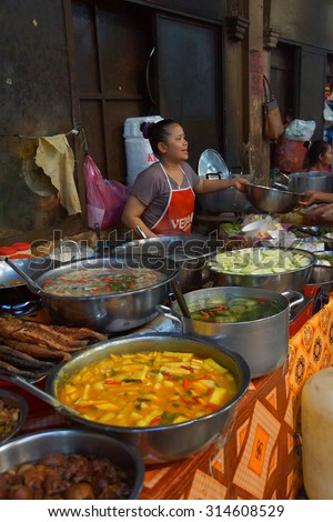 SIEM REAP, CAMBODIA - FEB 16, 2015 - Woman cooking lunch in the market of  Siem Reap,  Cambodia