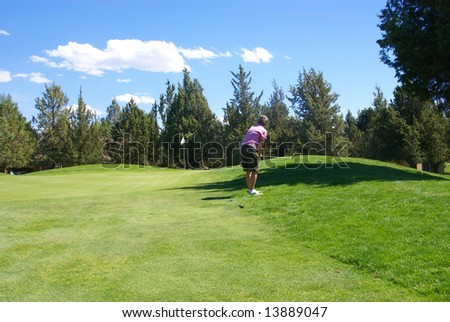 Lady golfer chipping ball to green,		Eagle Crest Resort Golf Course,	Central Oregon