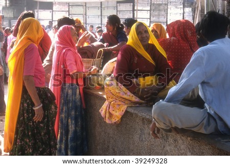 PUSHKAR, INDIA - NOVEMBER 8 : Women in brightly colored scarves and saris gather for a market during the Pushkar Camel Fair November 8, 2003 in Pushkar, India.