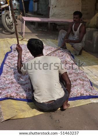 VARANASI, INDIA - NOV 7 - Men sew large mattress covers in their shops on Nov 7, 2009, in Varanasi, India.
