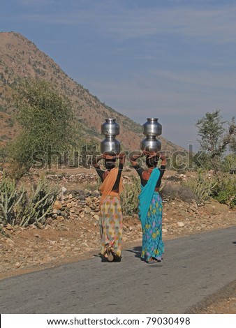 Young Indian women carry pots of water on their heads in Rajasthan, India.