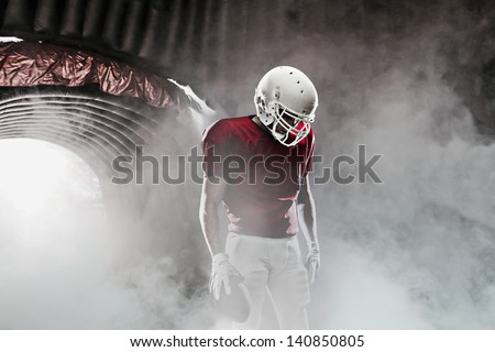 Football player, leaving a smoky tunnel, ready to get on the field