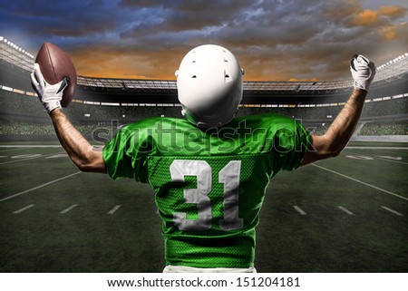 Football Player with a green uniform celebrating with the fans.