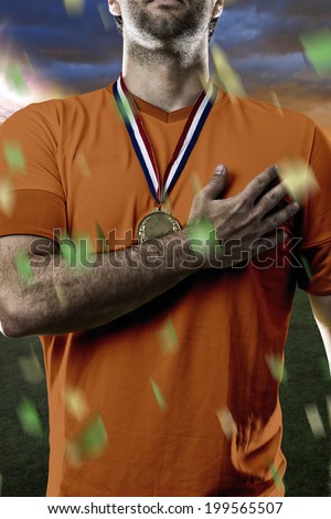 Dutchman soccer player, listening to the national anthem with his hand on his chest. On a Stadium.