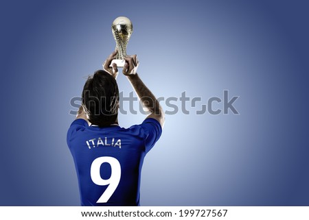 Italian soccer player, celebrating the championship with a trophy in his hand. On a blue background.