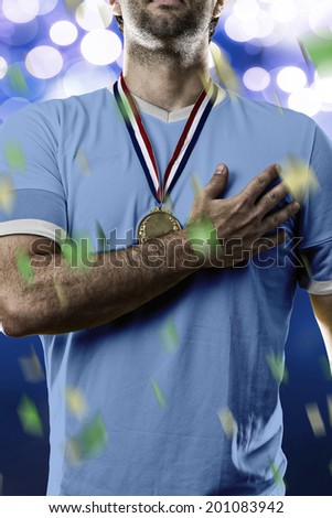 Uruguayan soccer player, listening to the national anthem with his hand on his chest. On a blue lights background.