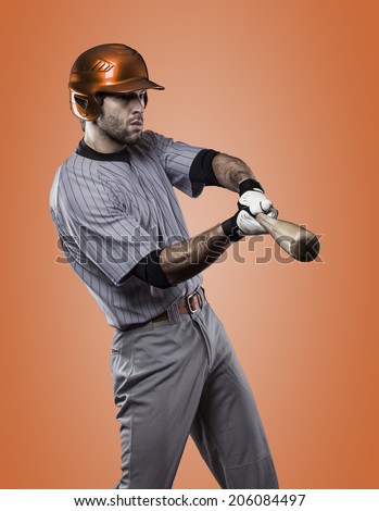Baseball Player on a orange Uniform on orange background.