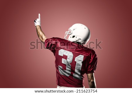 Football Player on a Red uniform celebrating on a red background.