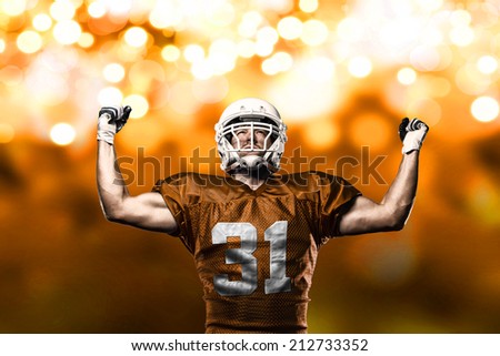 Football Player on a Orange uniform celebrating on a orange lights background.