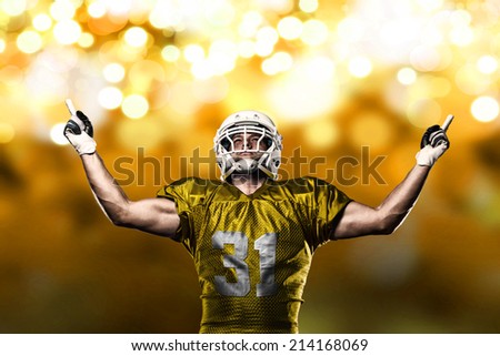Football Player on a yellow uniform celebrating on a yellow lights background.