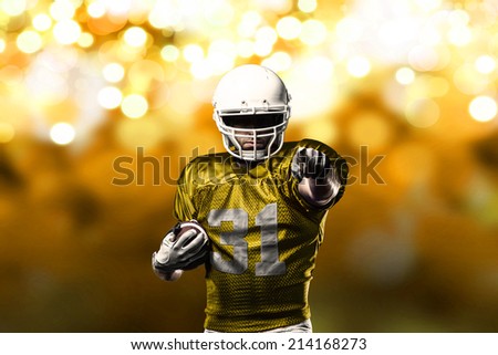 Football Player on a yellow uniform celebrating on a yellow lights background.
