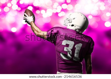Football Player on a pink uniform celebrating on a pink lights background.