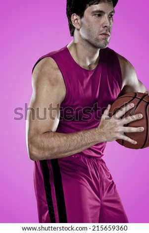 Basketball player on a  pink uniform, on a pink background.