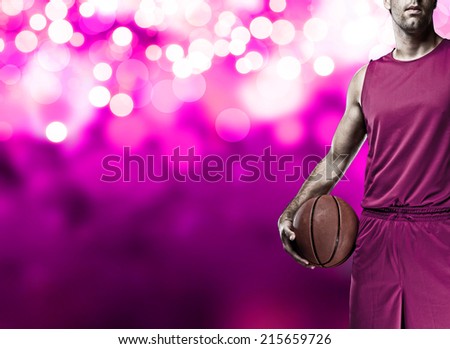 Basketball player on a  pink uniform, on a pink lights background.
