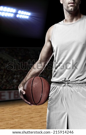 Basketball player on a  white uniform, on a basketball court.