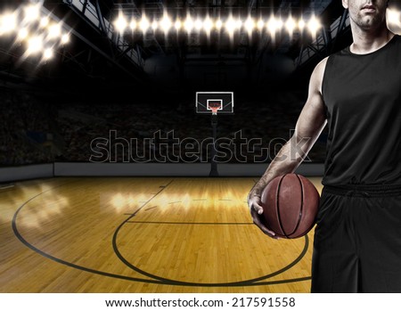 Basketball player on a  black uniform, on a basketball court.