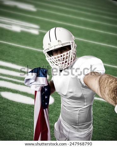 Football Player with a white uniform making a selfie on a football field.
