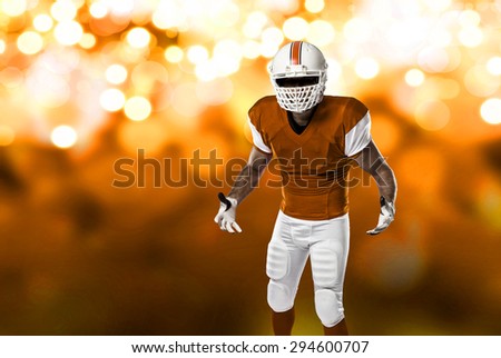 Football Player with a orange uniform on a orange lights background.