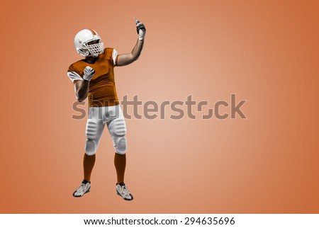 Football Player with a orange uniform making a selfie on a orange background.