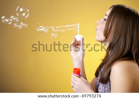 Portrait of an attractive young woman blowing soap bubbles