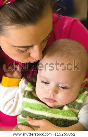 Mother kisses her son\'s head tenderly with love