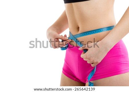 Fitness girl measuring her perfect shapeed beautiful waist. She lost weight, with white background