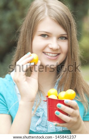 Beautiful girl holding yellow plums