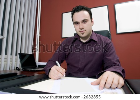 Businessman in his office writing document
