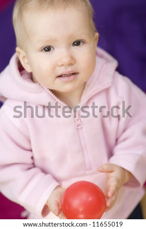 Girl with small ball on violet background