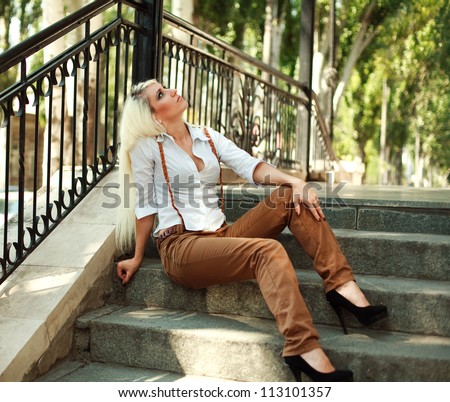 Young old fashioned girl sitting on the stage of vintage building